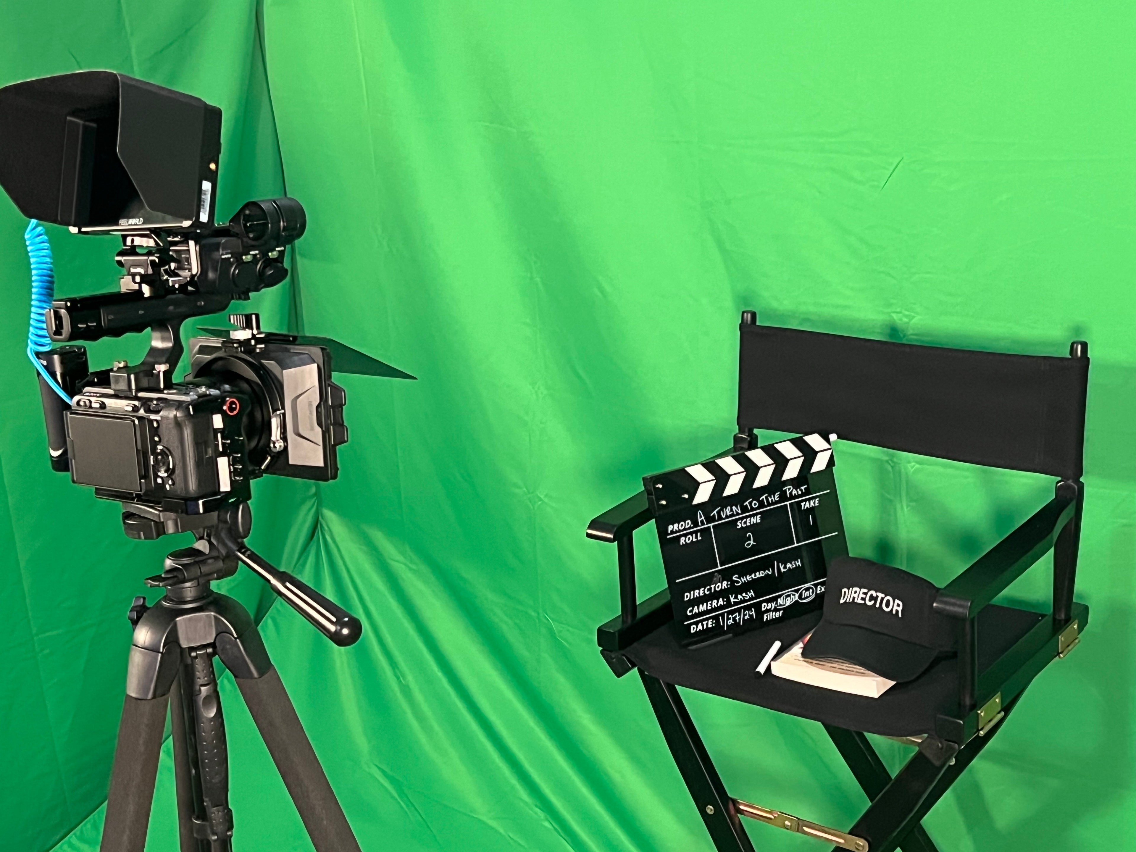 Film production setup with camera and director's chair on green screen